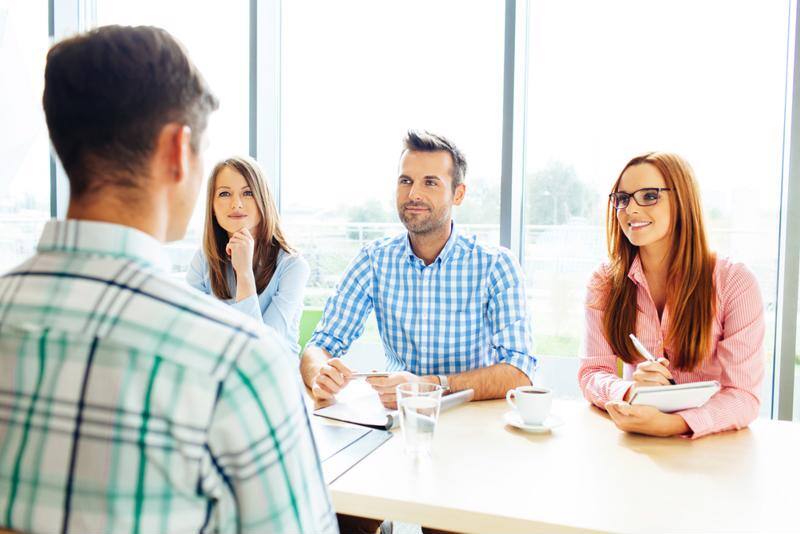 A man interviewing in front of a panel.